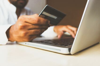 man ordering on laptop with credit card
